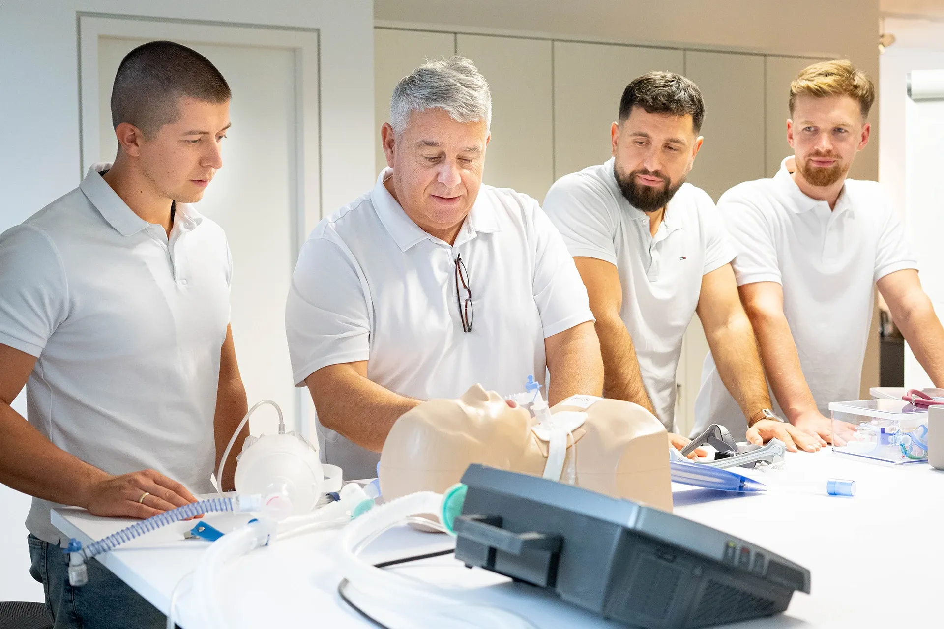 Vier Mitarbeiter von beatmet24 bei einer Schulung mit medizinischer Ausrüstung.