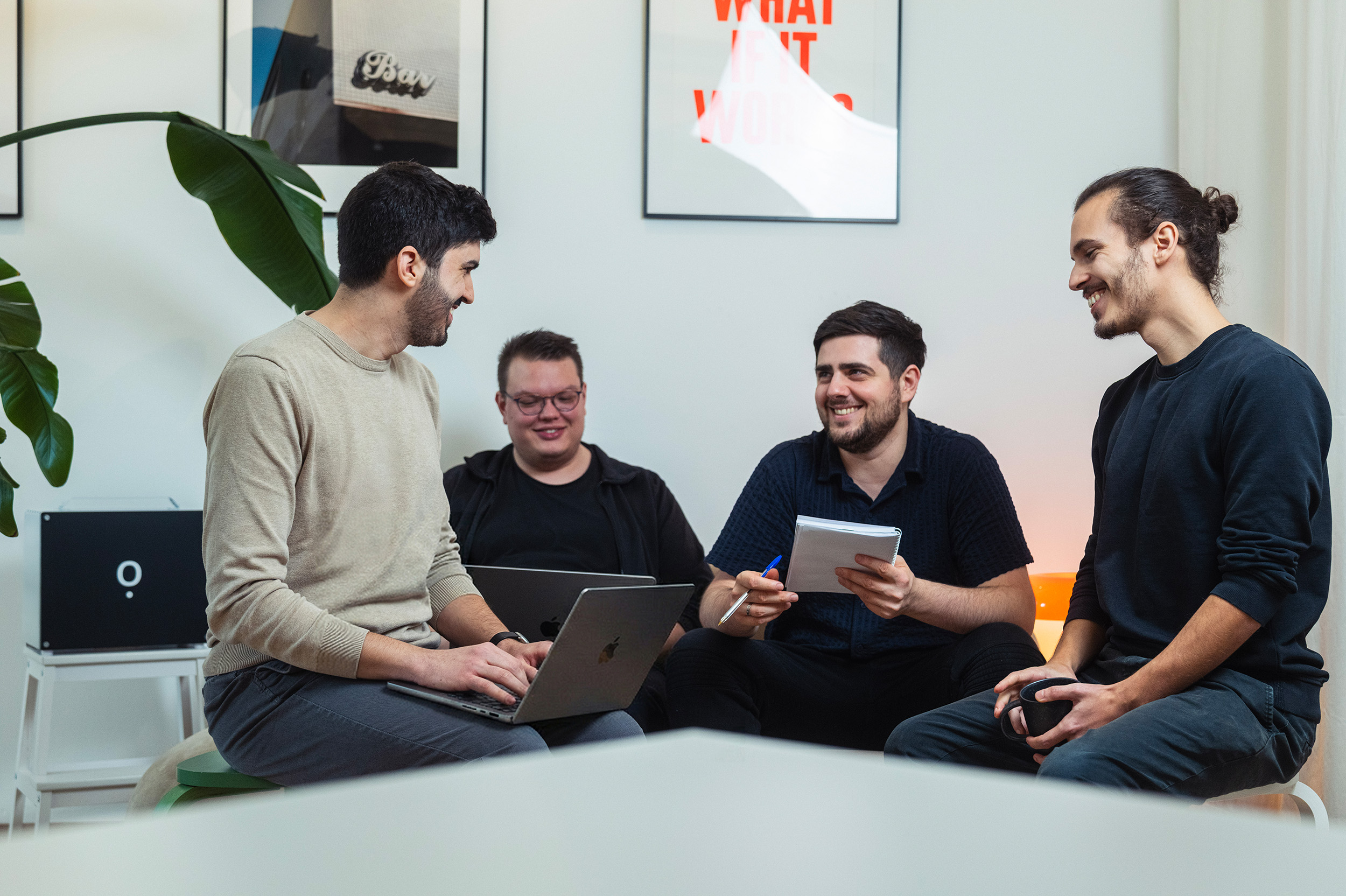 Das IOWIS-Team sitzt gemeinsam im Büro, bespricht Ideen mit Laptop und Notizblock, im Hintergrund steht die Airene-KI-Box.