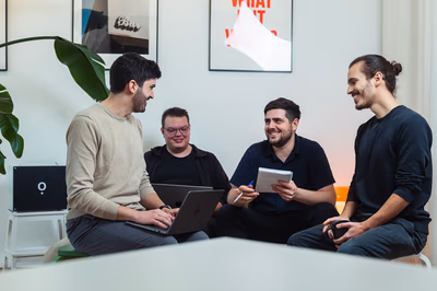 Das IOWIS-Team sitzt gemeinsam im Büro, bespricht Ideen mit Laptop und Notizblock, im Hintergrund steht die Airene-KI-Box.