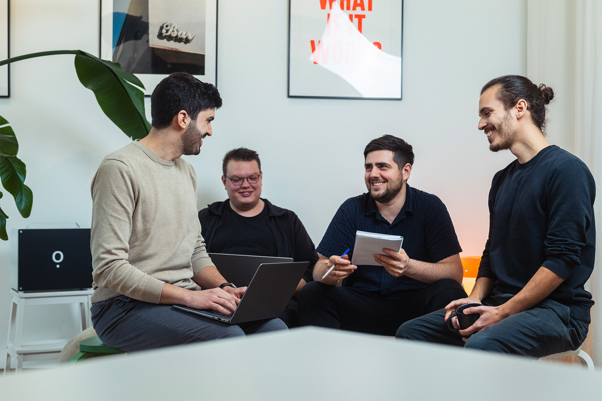 Das IOWIS-Team sitzt gemeinsam im Büro, bespricht Ideen mit Laptop und Notizblock.