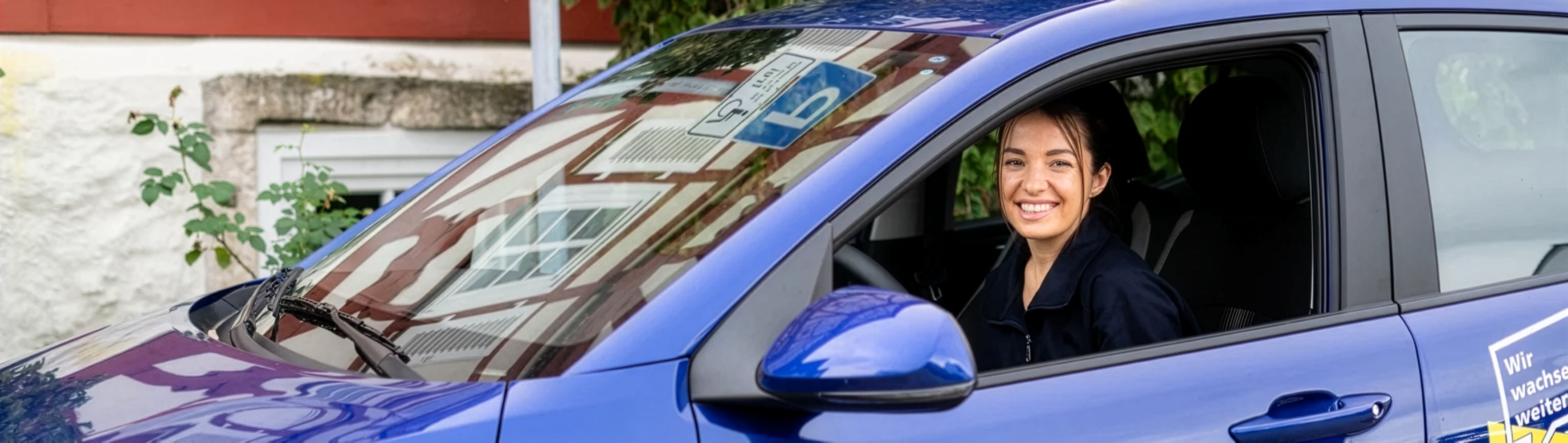 Pflegekraft von beatmet24 in einem blauen Dienstfahrzeug im mobilen Arbeitsalltag.